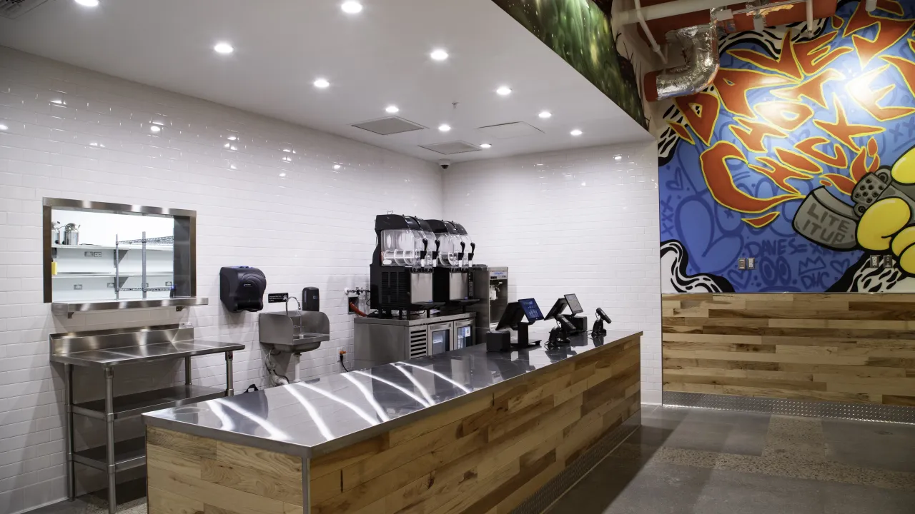 Interior view of Dave’s Hot Chicken at 11525 W. Broad St, Richmond, VA, showcasing a modern counter and brightly colored mural.