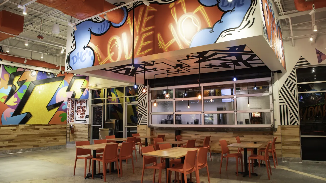 Interior view of Dave's Hot Chicken on W. Broad St, Richmond, VA, showcasing hand painted murals and modern seating.