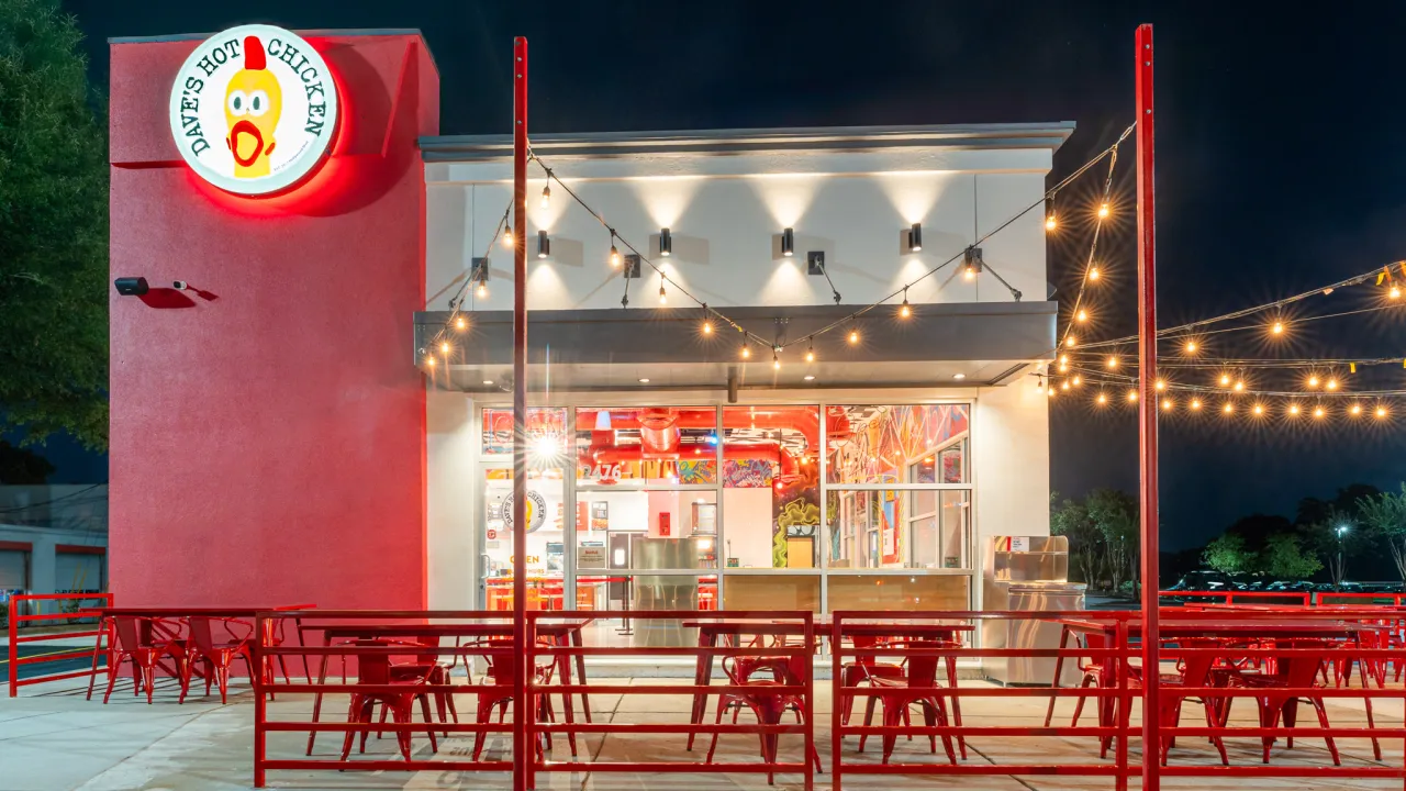 Exterior view of Dave's Hot Chicken on Cherry Rd, Rock Hill, SC, showcasing vibrant red decor and outdoor seating.