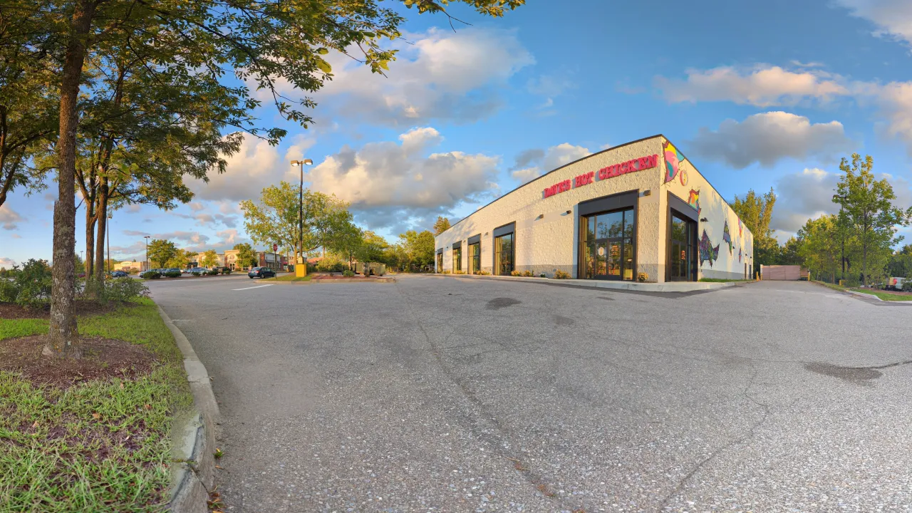 Exterior view of Dave's Hot Chicken at 225 Dorset St, South Burlington, VT, showcasing vibrant murals and inviting entrance.