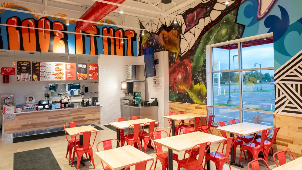 Interior view of vibrant dining area at 3574 Main Street, Unit 102, Coon Rapids, MN, featuring colorful murals and red chairs.