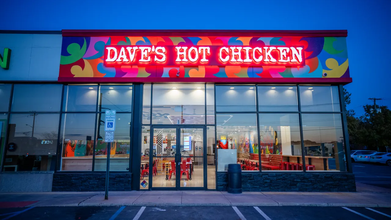 Exterior view of Dave's Hot Chicken on NJ-18, East Brunswick, NJ, showcasing vibrant signage and colorful decor.