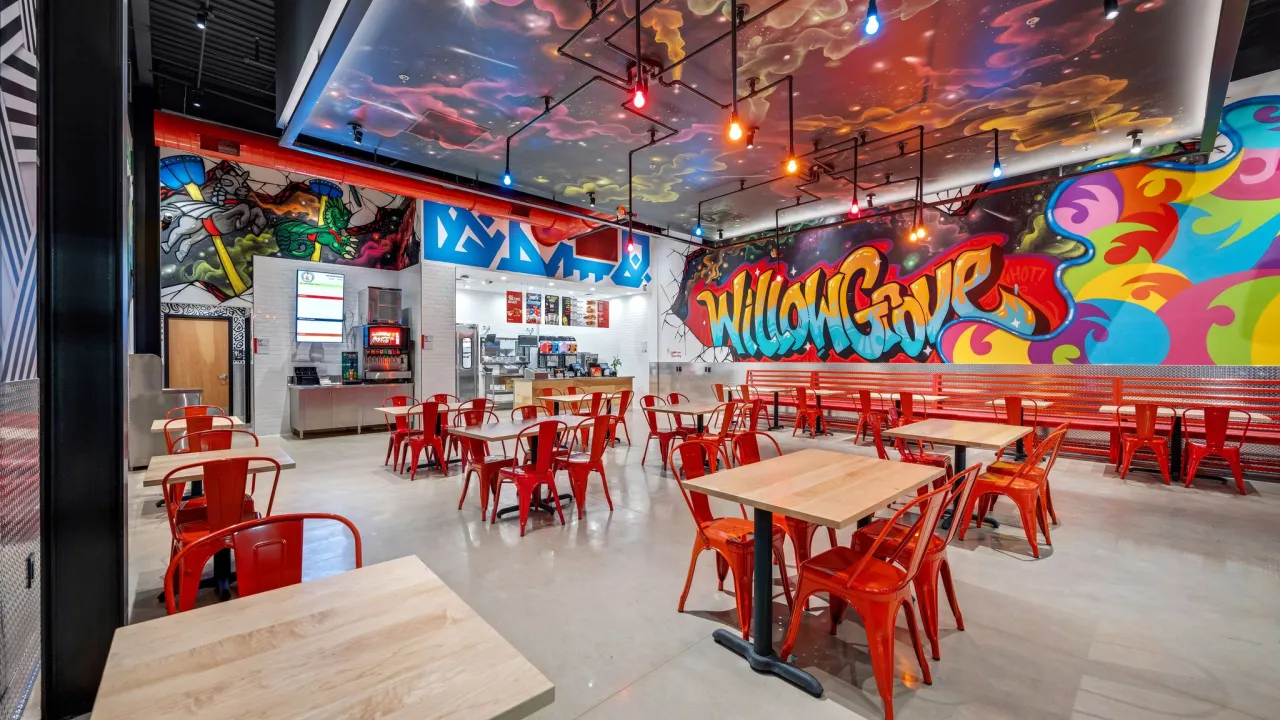 Interior view of Dave's Hot Chicken on Park Ave, Willow Grove, PA, featuring vibrant murals and the service counter.