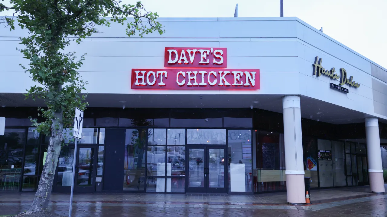 Exterior view of Dave's Hot Chicken at 700 Plaza Dr, Secaucus, NJ, featuring bold red signage and large glass windows.