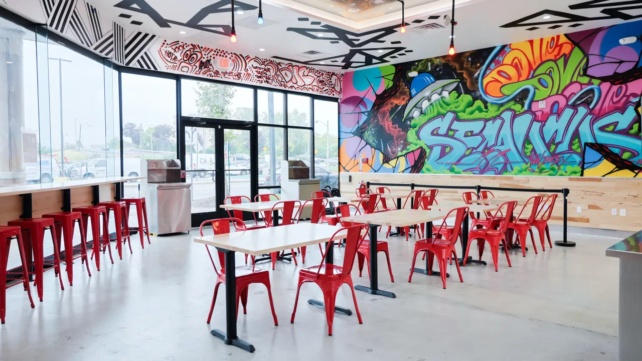 Interior view of Dave's Hot Chicken at 700 Plaza Dr, Secaucus, featuring colorful Secaucus mural.