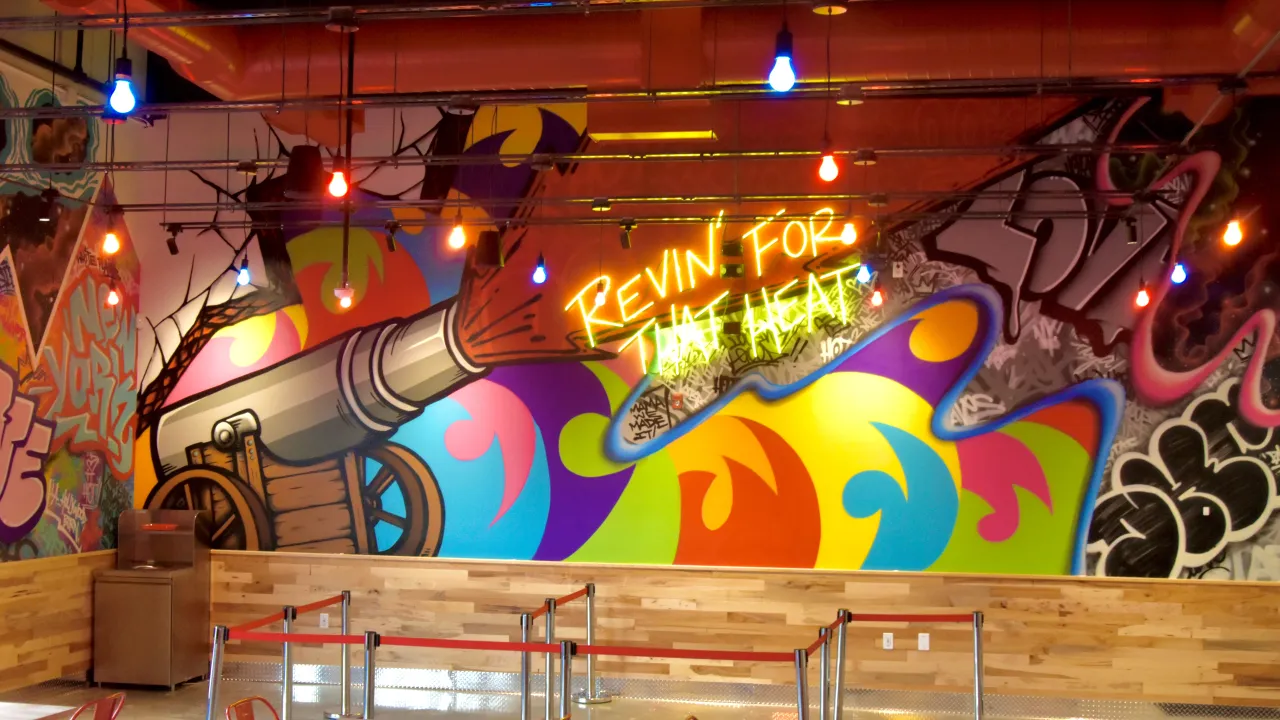 Interior view of Dave's Hot Chicken, 489 Tarrytown Rd, White Plains, NY, featuring vibrant mural and unique lighting.