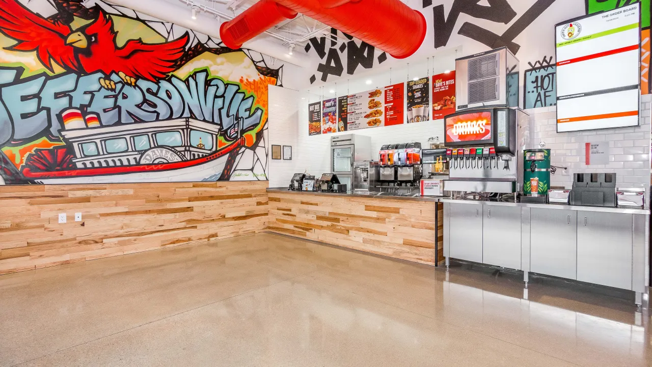 Interior view of Dave’s Hot Chicken in Jeffersonville, IN, showcasing a vibrant mural and modern decor.