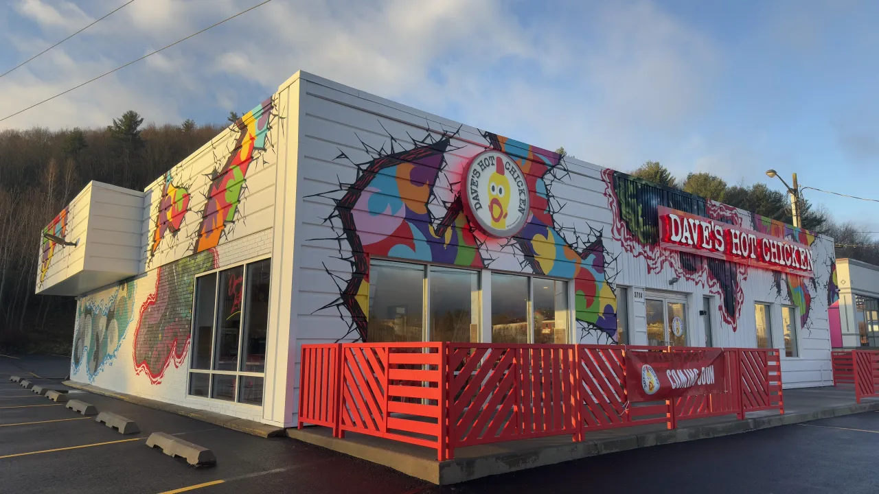 Exterior view of Dave's Hot Chicken on Vestal Pkwy E, Vestal, NY, featuring colorful murals and bold signage.