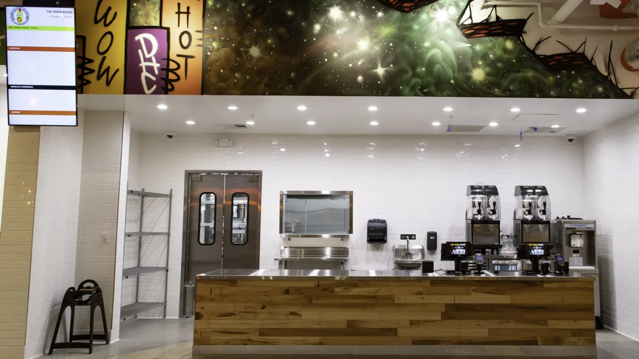 Interior view of Dave’s Hot Chicken at 11525 W. Broad St, Richmond, VA, showcasing the modern counter and vibrant mural.