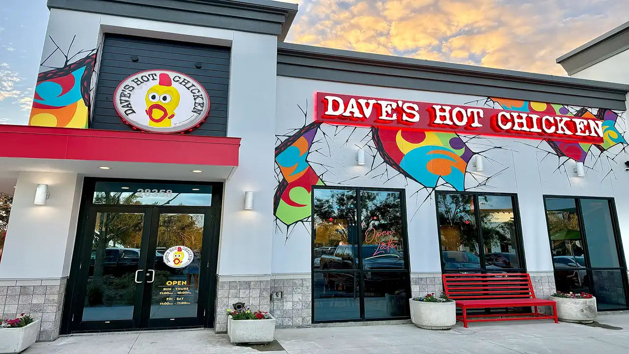 Front exterior of Dave’s Hot Chicken on Willet Way, Wesley Chapel, FL, with bold red signage and vibrant murals.