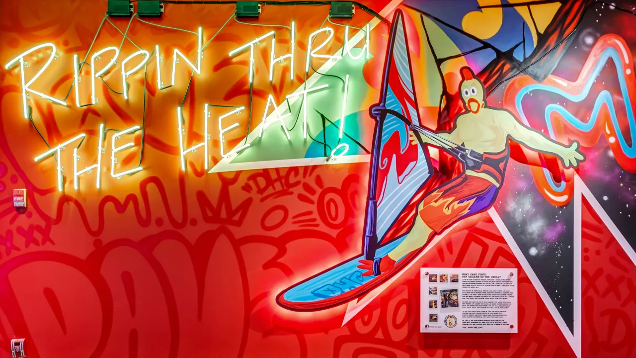 Interior mural at Dave's Hot Chicken on Boston Post Rd, Milford, CT, showcasing vibrant colors and playful artwork.