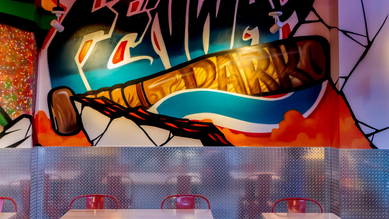 Interior view of Dave’s Hot Chicken on Boylston Street, Boston, MA, showcasing vibrant murals and metallic decor.