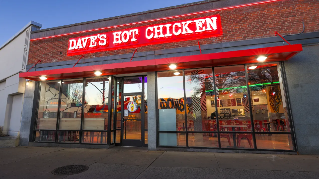 Exterior view of Dave's Hot Chicken on 61-45 188th St, Fresh Meadows, NY, showcasing bright red signage and modern decor.