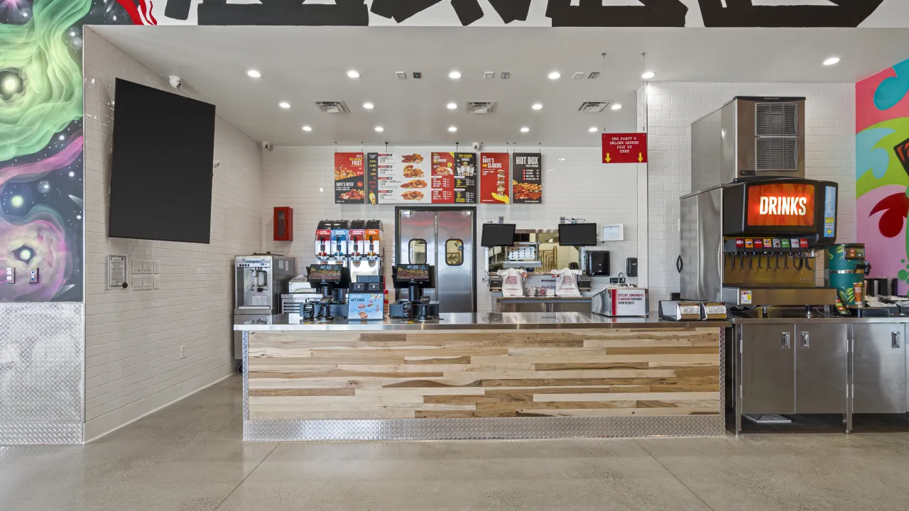 Interior view of Dave's Hot Chicken at 4215 W. Wisconsin Ave, Appleton, WI, showcasing a modern counter and vibrant decor.