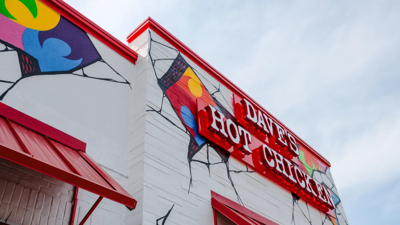 Exterior view of Dave's Hot Chicken at 1501 Quentin Rd, Lebanon, PA, showcasing colorful murals and bold red signage.