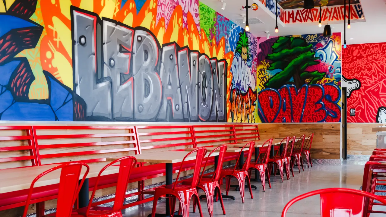 Interior view of Dave's Hot Chicken at 1501 Quentin Rd, Lebanon, PA, showcasing vibrant murals and red seating.