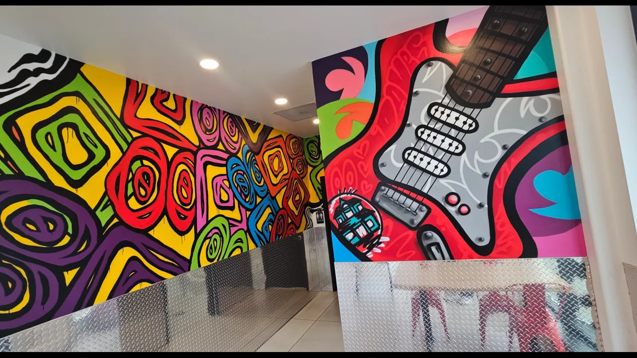 Interior view of Dave's Hot Chicken on E. Ridge Rd, Rochester, NY, showcasing vibrant murals and modern decor.