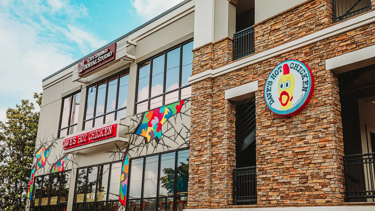 Exterior view of Dave's Hot Chicken on Roswell Road, Sandy Springs, GA, showcasing colorful mural and prominent signage.
