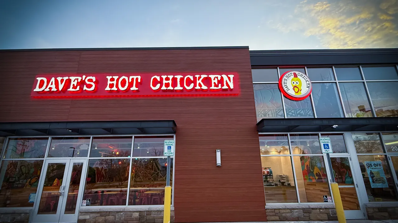 Exterior view of Dave's Hot Chicken on N. Squirrel Rd, Auburn Hills, MI, showcasing bright red signage and modern design.