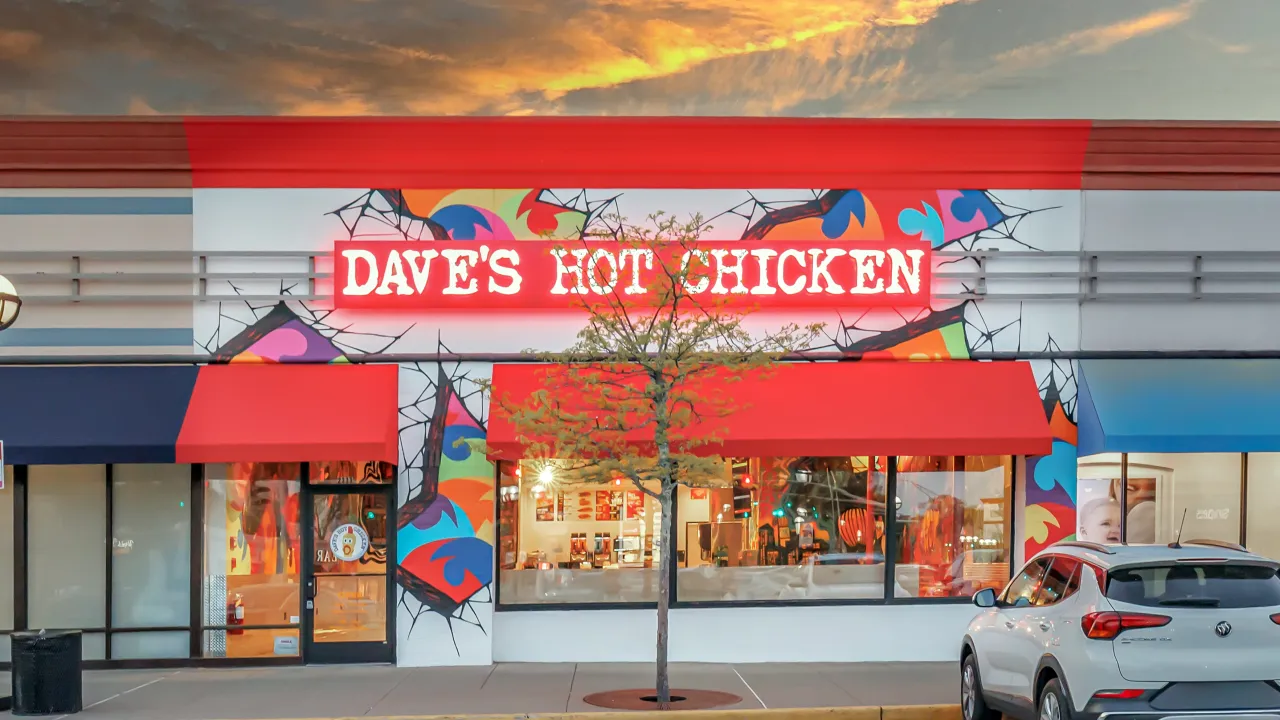 Exterior view of Dave’s Hot Chicken on Summer St, Stamford, CT, showcasing vibrant murals and bright red signage.