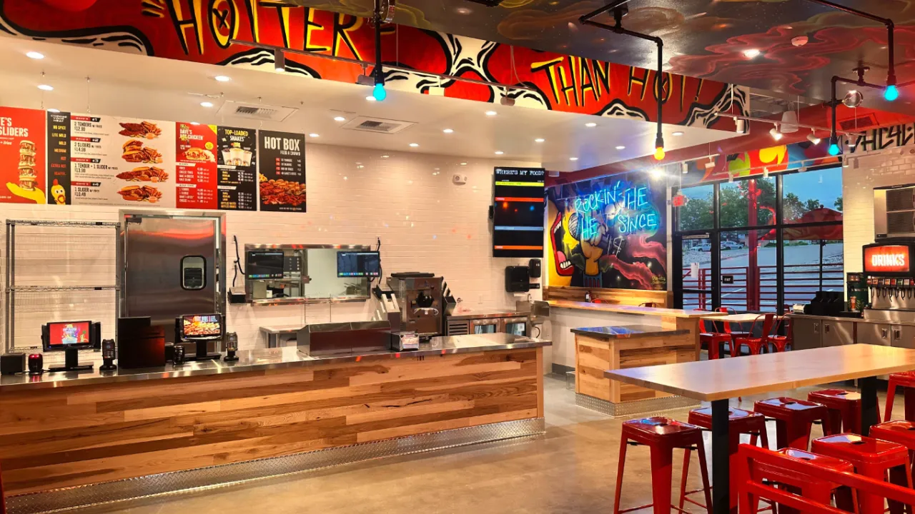 Interior view of Dave's Hot Chicken on E. Arapahoe Rd, Greenwood Village, CO, featuring vibrant murals and modern seating.