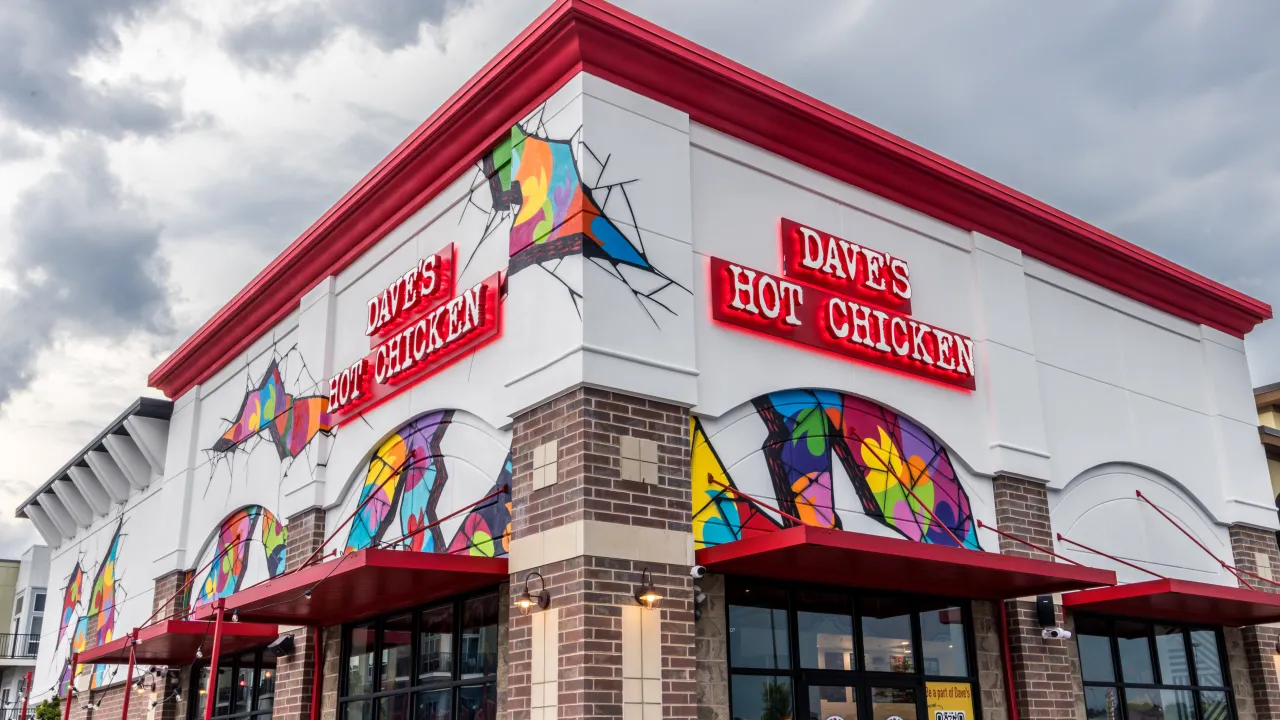 Exterior view of Dave's Hot Chicken at 3208 Vandercar Way, Cincinnati, OH, showcasing colorful murals and bright signage.