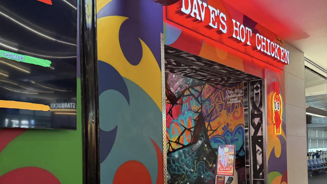 Interior view of Dave's Hot Chicken on Wayne Newton Blvd, Las Vegas, NV, featuring vibrant murals and bold signage.