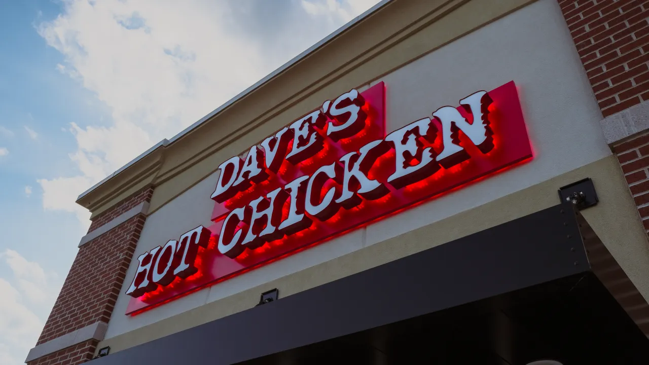 Exterior view of Dave's Hot Chicken on Gateway Ave, Chambersburg, PA, showcasing the vibrant red signage against a blue sky.