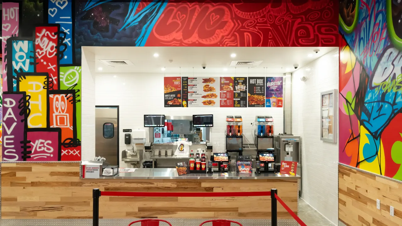 Interior view of Dave's Hot Chicken at 744 NJ-70 W, Brick, NJ, showcasing vibrant murals and a modern counter setup.