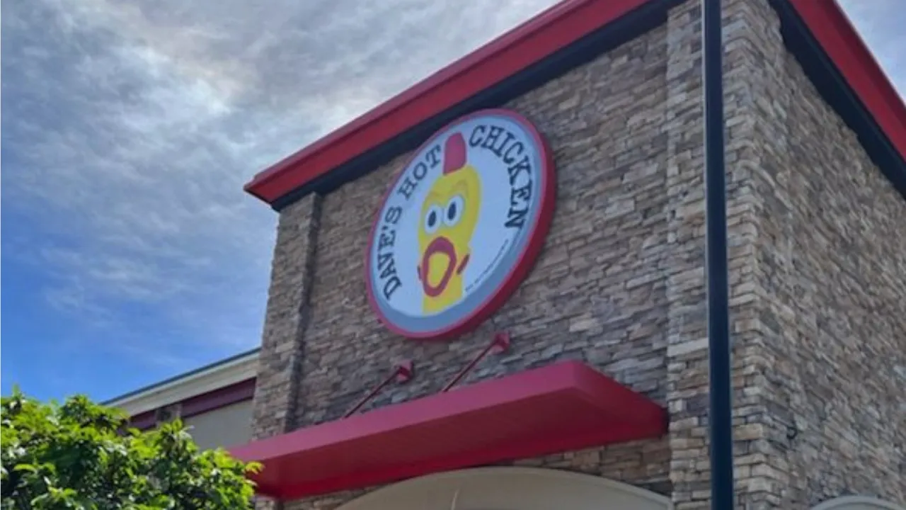 Exterior view of Dave's Hot Chicken at 2521 South Rd, Poughkeepsie, NY, showcasing vibrant signage and stonework.