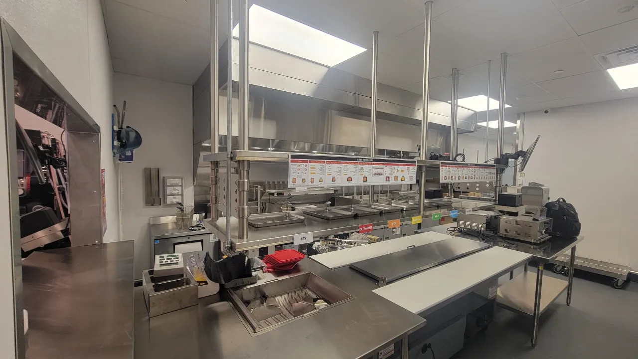 Interior view of the kitchen at Dave's Hot Chicken on South Rd, Poughkeepsie, NY, showcasing modern stainless steel equipment and signage.