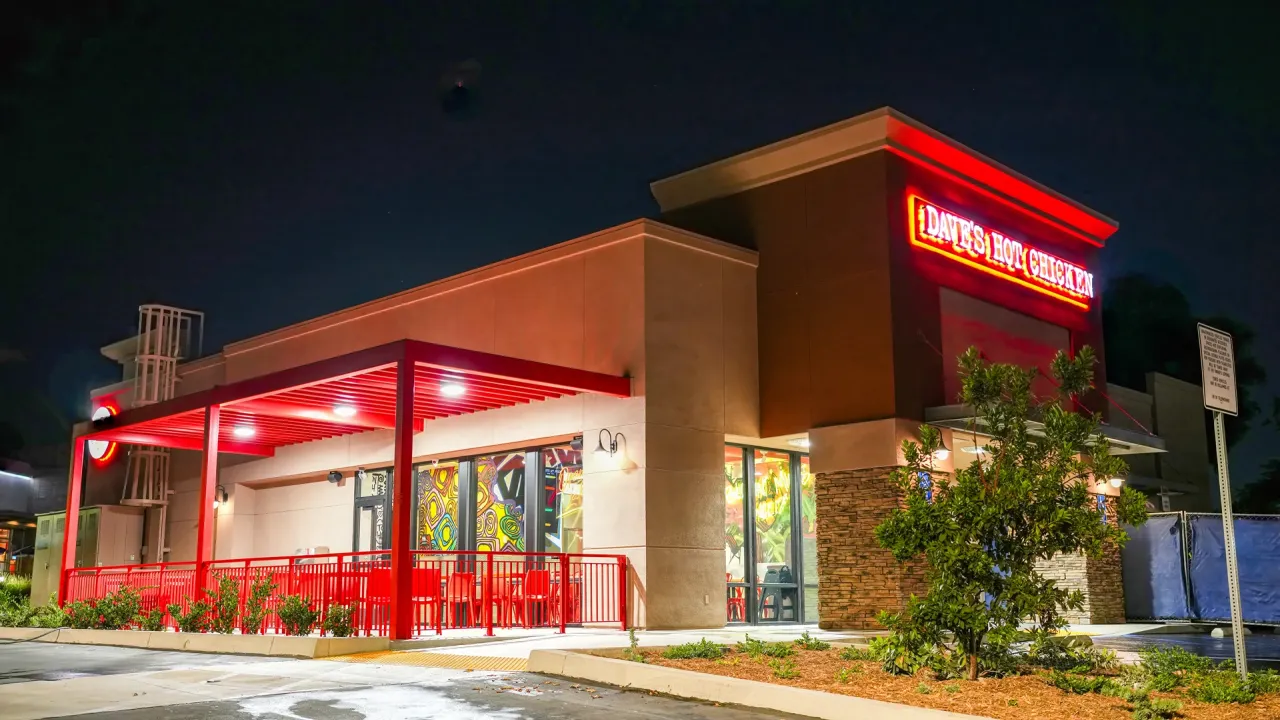Exterior view of Dave's Hot Chicken on South Indian Hill Blvd, Claremont, CA, showcasing vibrant red signage and outdoor seating.