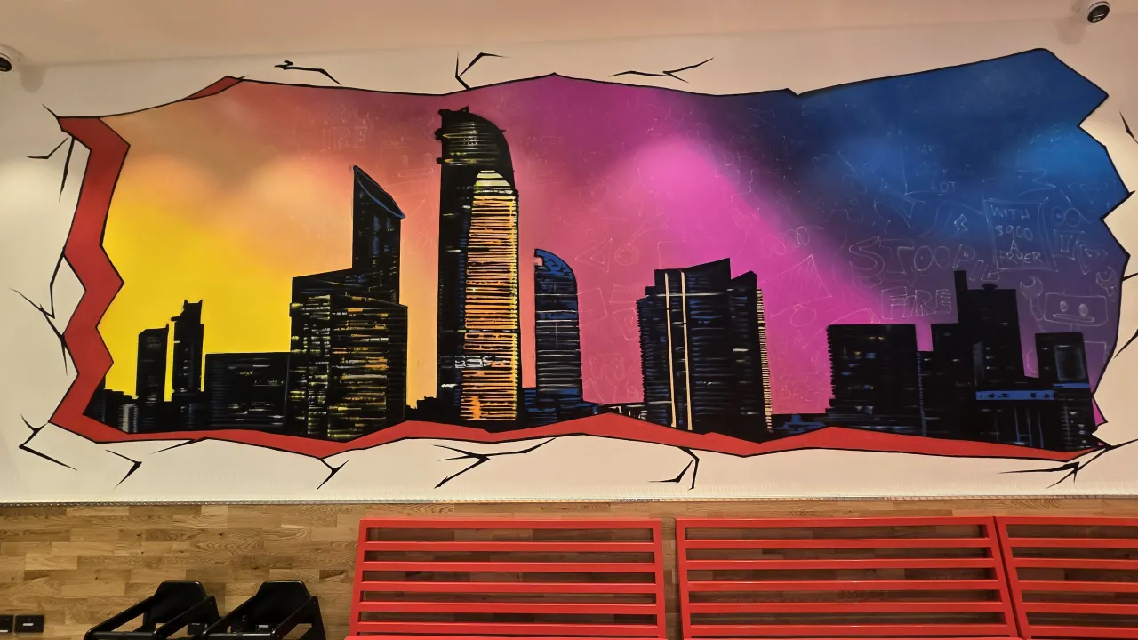 Interior mural at Dave's Hot Chicken on King Salman Bin Abdulaziz Al Saud Street, Abu Dhabi, Abu Dhabi, showcasing vibrant city skyline art.