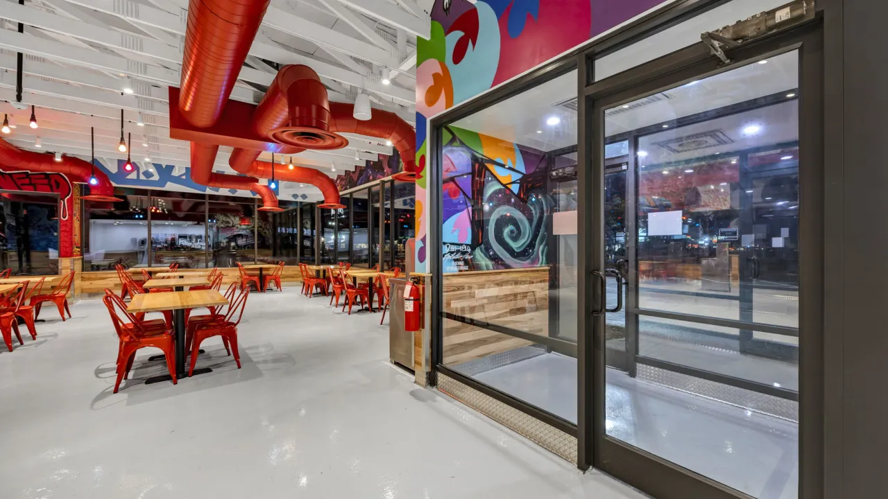 Interior view of Dave's Hot Chicken at 1923 W. Palmetto St, Florence, SC, showcasing vibrant murals and modern seating.