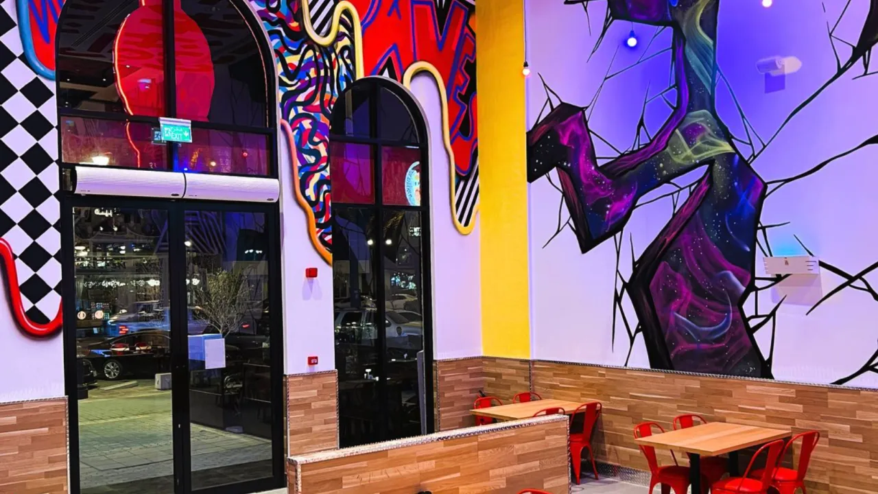 Interior view of Dave's Hot Chicken on Prince Muhammad Ibn Abd Al Aziz, Riyadh, KSA, showcasing vibrant murals and seating.