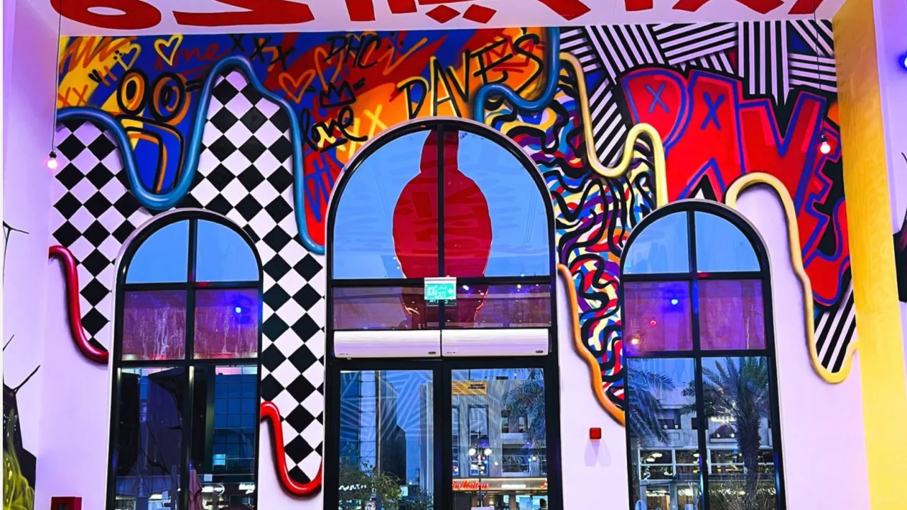 Interior view of Dave's Hot Chicken on Prince Muhammad Ibn Abd Al Aziz, Riyadh, KSA, showcasing vibrant murals and large windows.