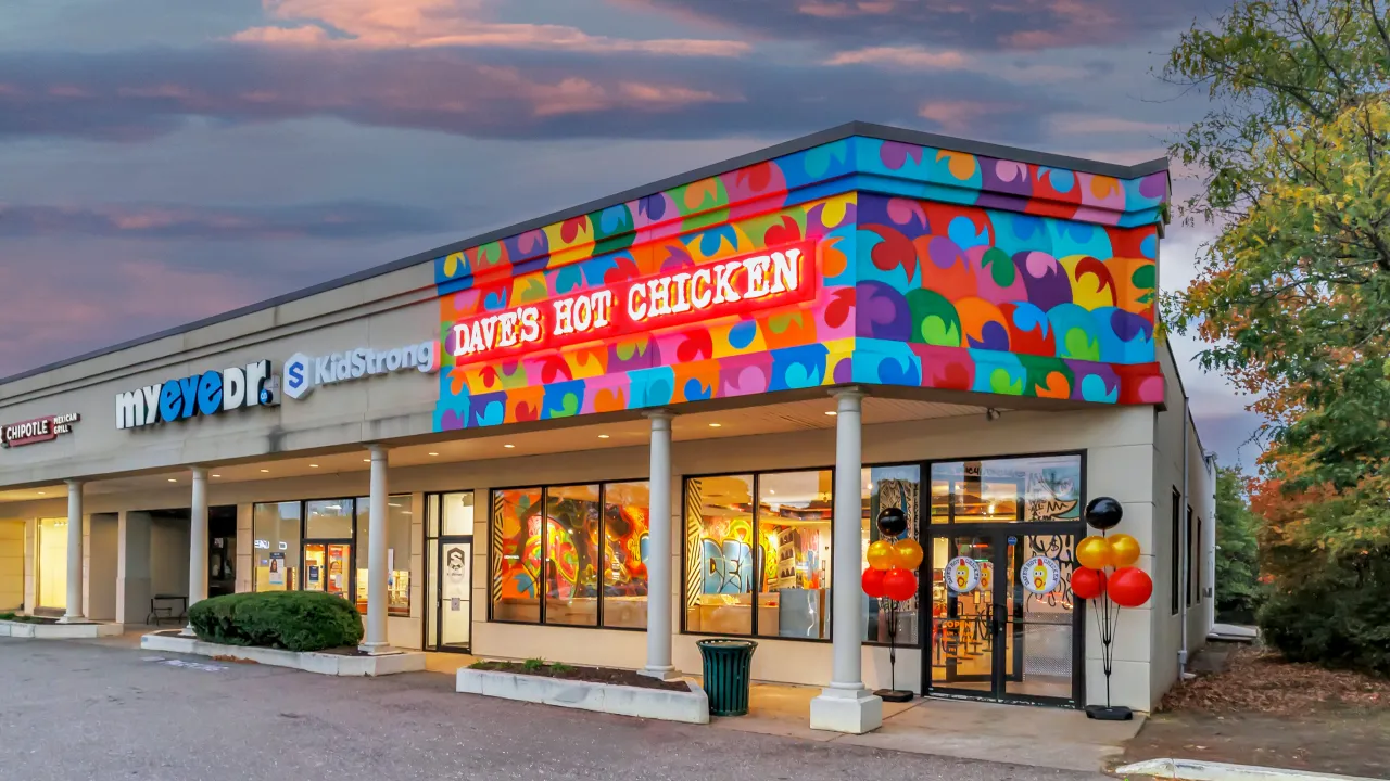 Exterior view of Dave's Hot Chicken on Dixwell Ave, Hamden, CT, showcasing vibrant mural and bright signage.