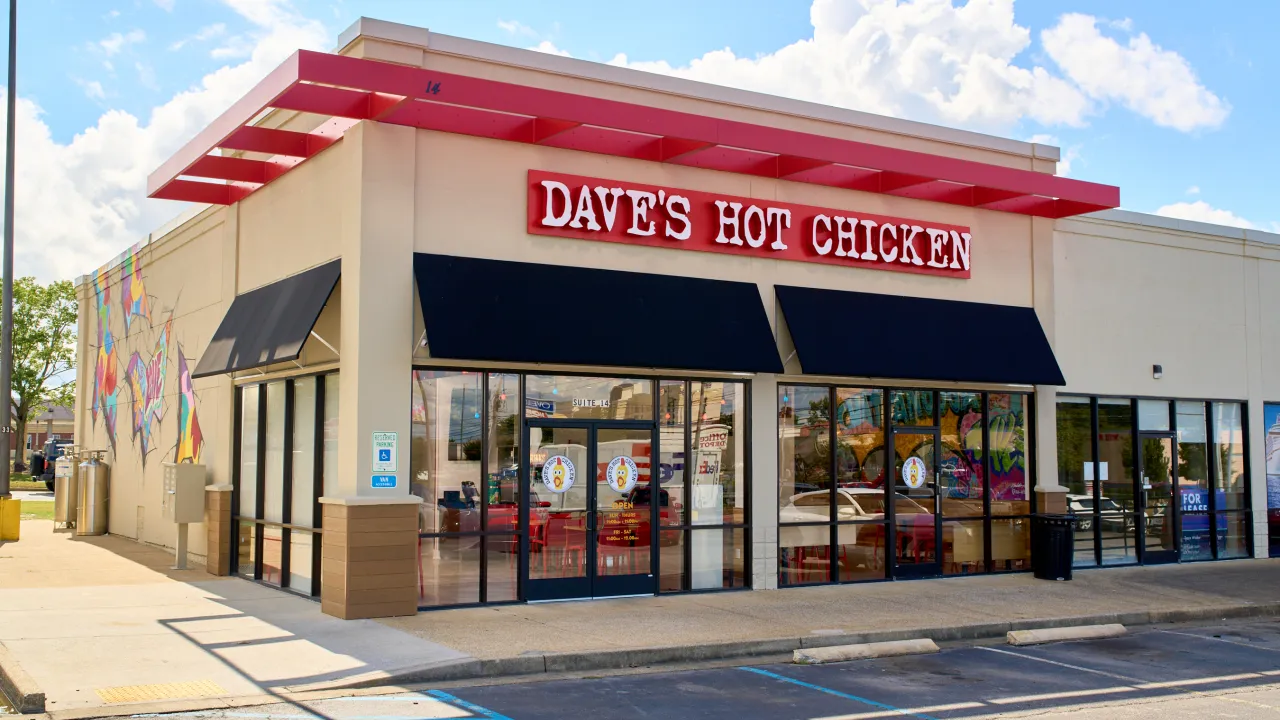 Exterior view of Dave's Hot Chicken on Gunbarrel Rd, Chattanooga, TN, showcasing vibrant murals and red signage.