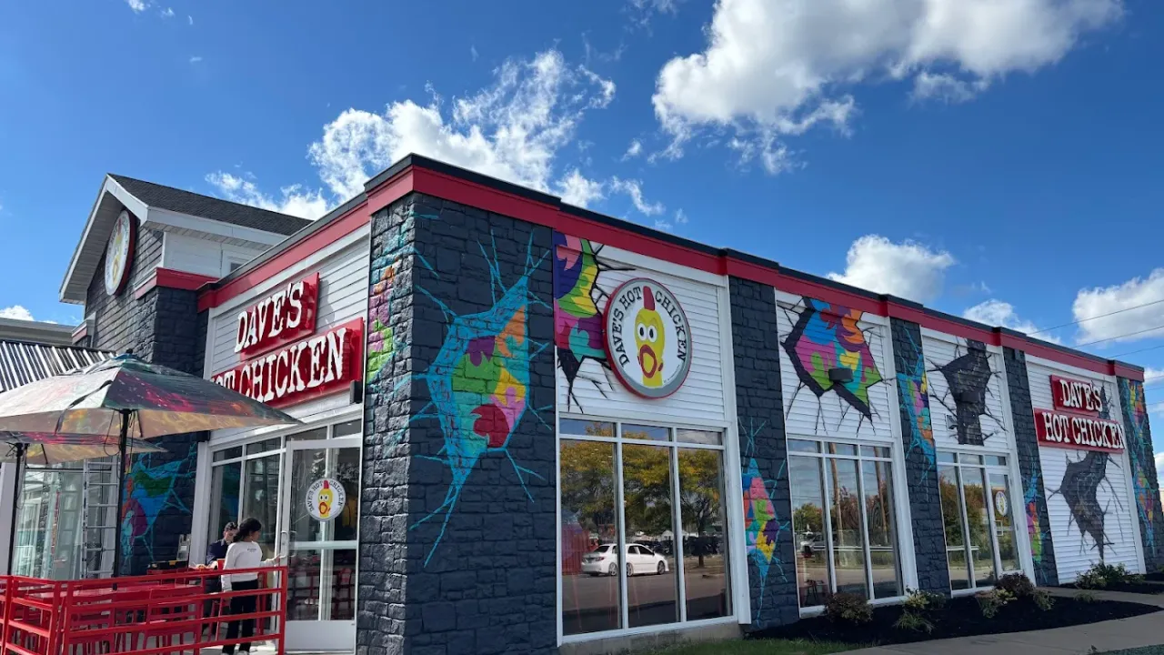 Exterior view of Dave's Hot Chicken at 3560 McKinley Pkwy, Buffalo, NY, showcasing vibrant murals and bold signage.
