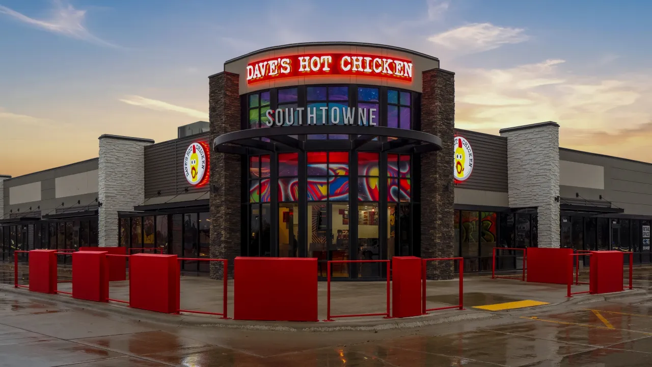 Exterior view of Dave's Hot Chicken at 2650 32nd Ave S, Grand Forks, ND, showcasing vibrant signage and colorful murals.