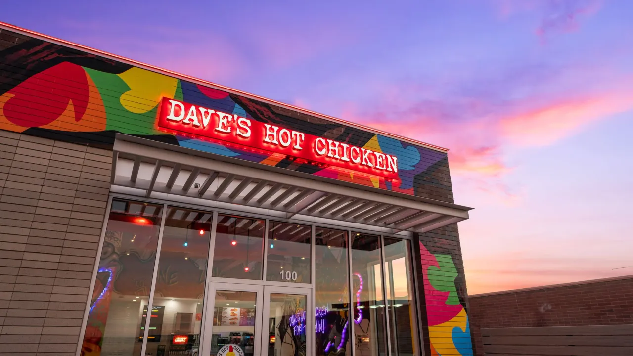 Exterior view of Dave's Hot Chicken at 4182 W. 13400 S., Suite 100, Riverton, UT, showcasing colorful mural and bright signage.