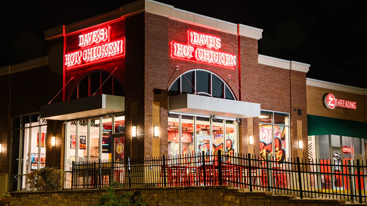 Exterior view of Dave's Hot Chicken at 1052 N Ballas Rd, Des Peres, MO, showcasing bright red signage and vibrant decor.