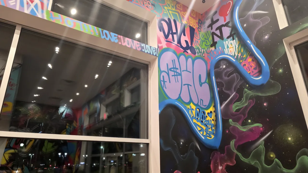 Interior view of Dave's Hot Chicken at 412 Balltown Rd, Schenectady, NY, showcasing vibrant graffiti art and modern decor.