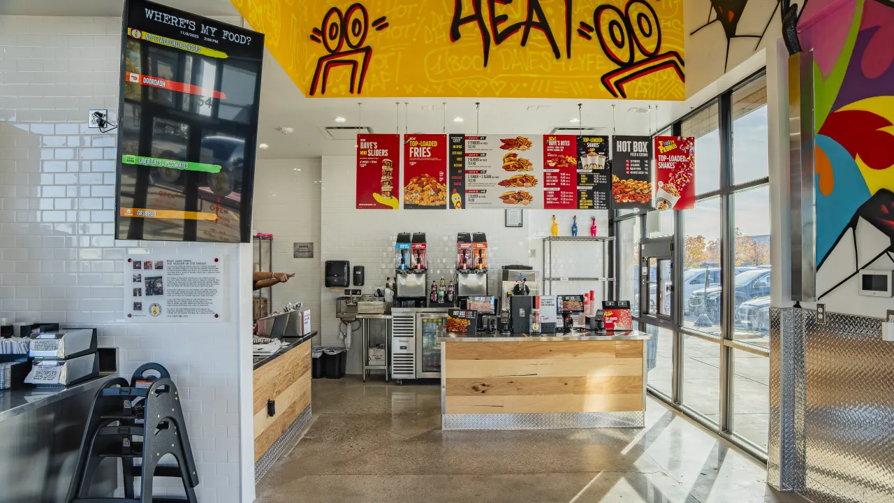 Interior view of Dave's Hot Chicken at 7454 S. Olympia Avenue, Tulsa, OK, showcasing colorful menus and modern decor.