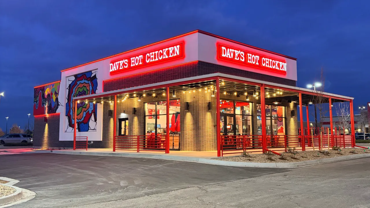 Exterior view of Dave's Hot Chicken on Arizona Place, Aurora, CO, showcasing vibrant mural and bright red signage.