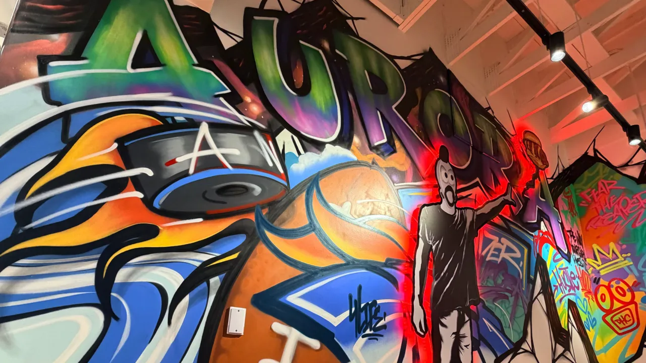 Interior view of Dave's Hot Chicken on Iola Street, Aurora, CO, showcasing vibrant murals and lively decor.