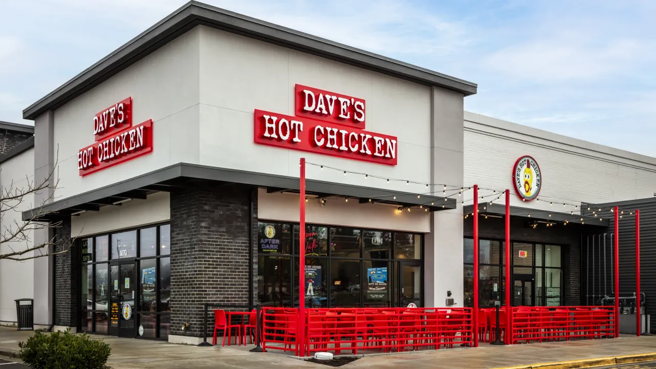 Exterior view of Dave's Hot Chicken on S Commons, Federal Way, WA, showcasing bold red signage and outdoor seating.