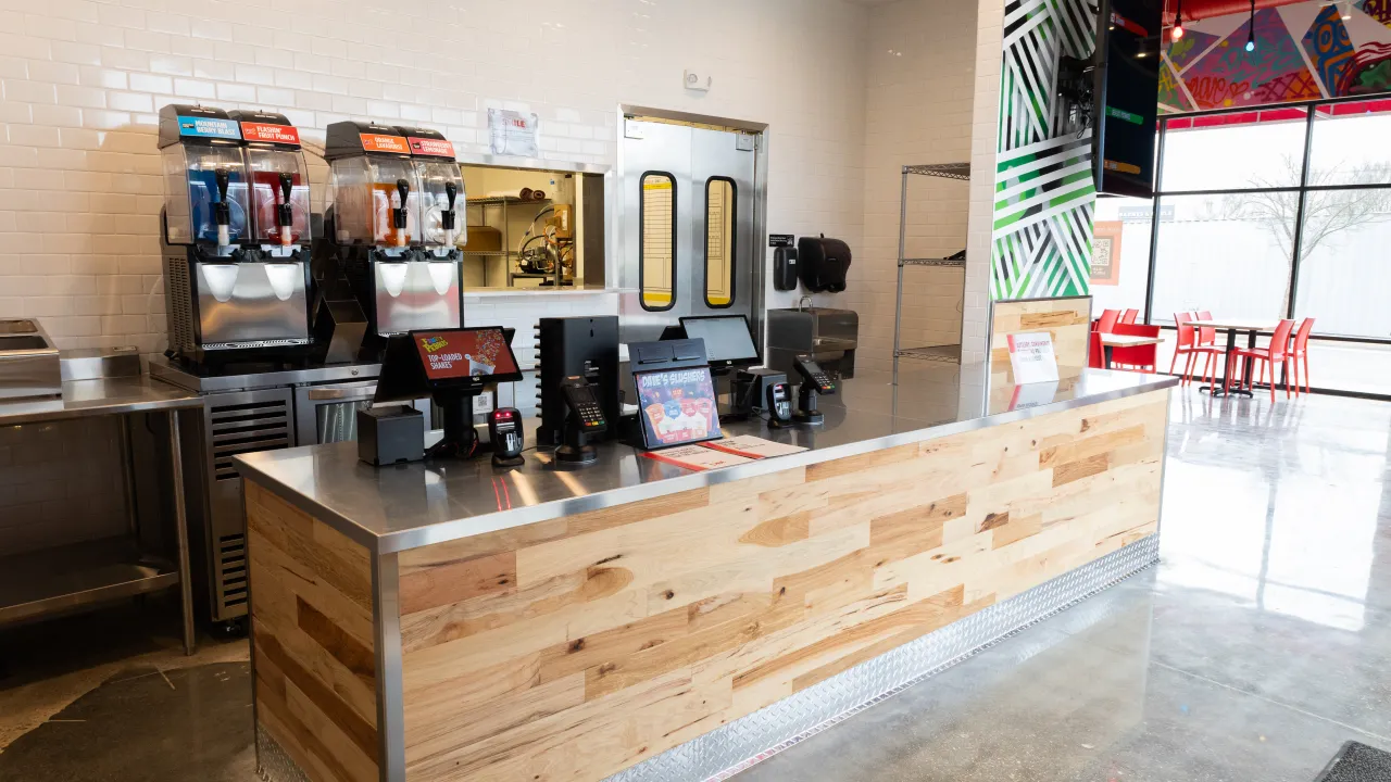 Interior view of the service counter at 27306 Crossing Cir, Denham Springs, LA, showcasing modern decor and beverage machines.