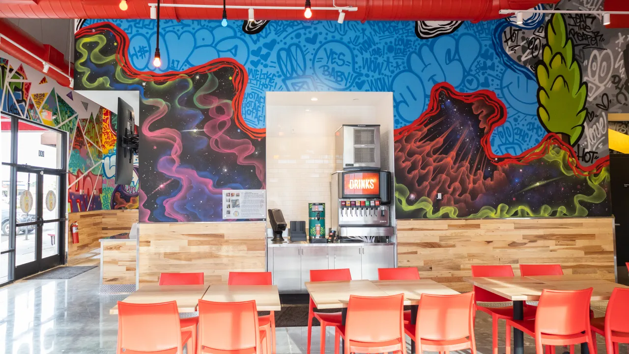 Interior view of vibrant mural at 27306 Crossing Cir, Denham Springs, LA, showcasing colorful graffiti and seating.