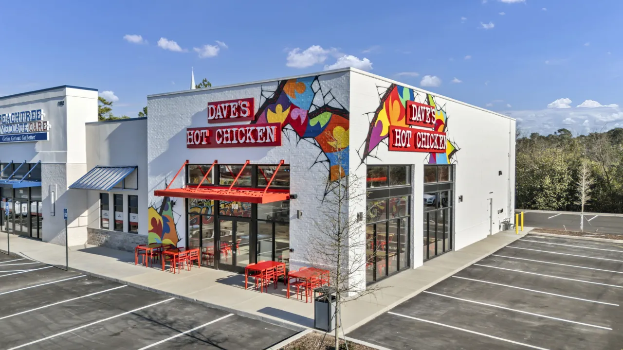 Exterior view of Dave's Hot Chicken at 1102 Trust Ave, Augusta, GA, showcasing colorful murals and outdoor seating.